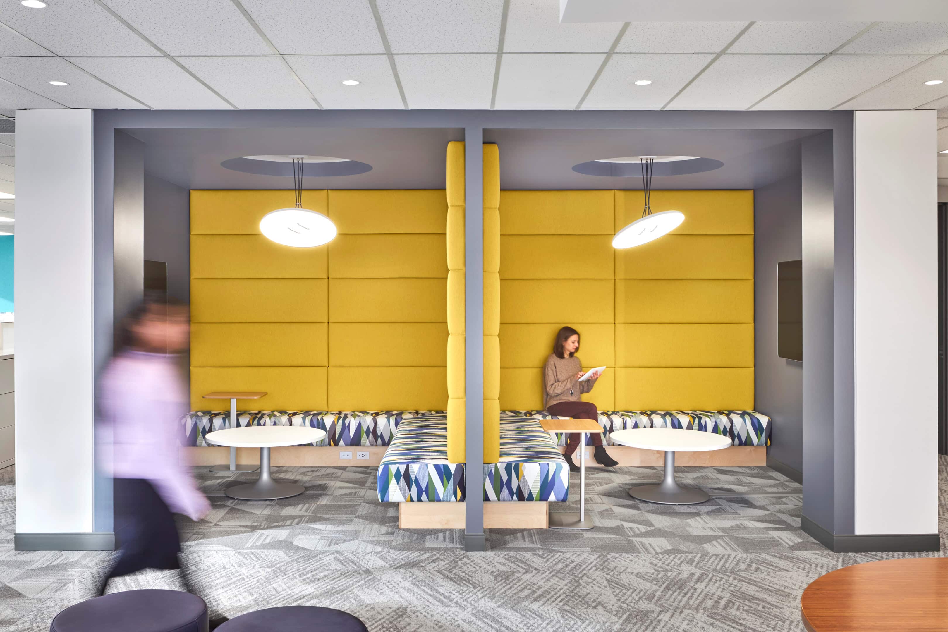Lounge lighting with disc pendants over yellow accent wall at GC Workplace, Ottawa