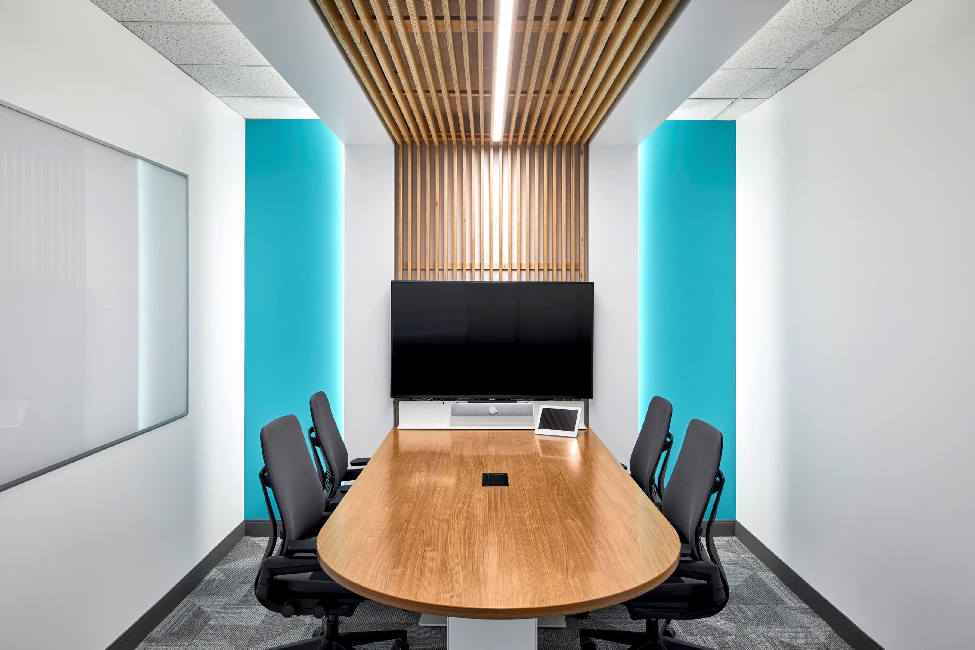 Meeting room lighting with cove lighting and teal accent walls at GC Workplace, Ottawa