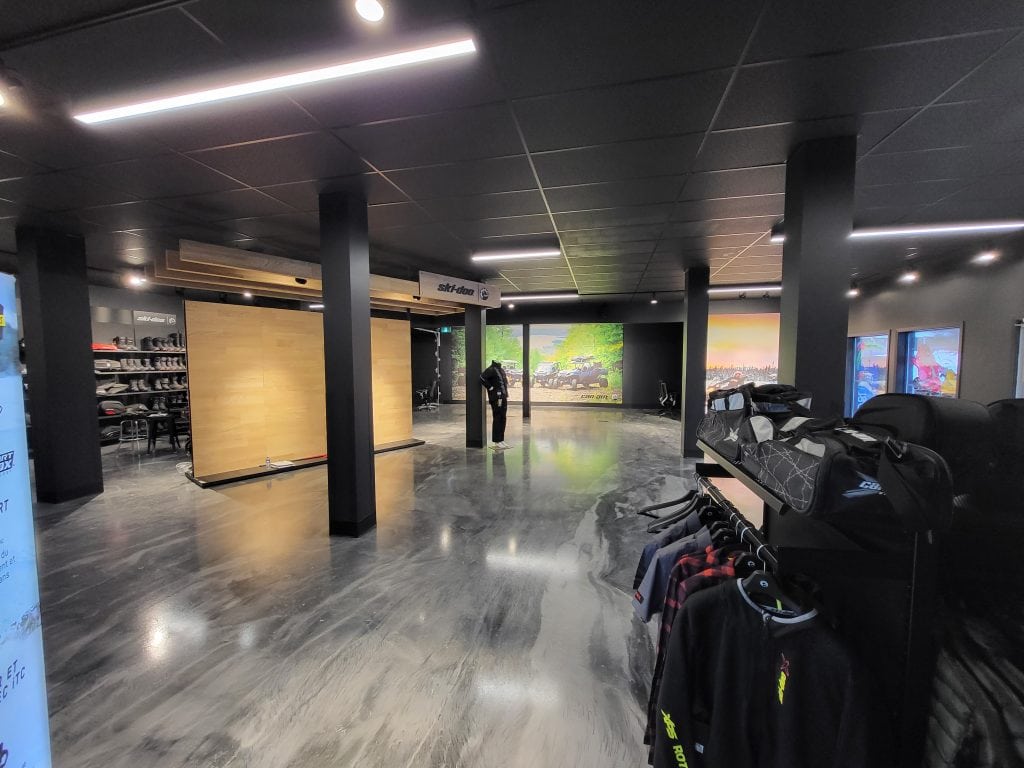 Retail lighting with track fixtures over apparel racks at Gauvreau Ski-Doo, Sainte-Cecile-de-Masham