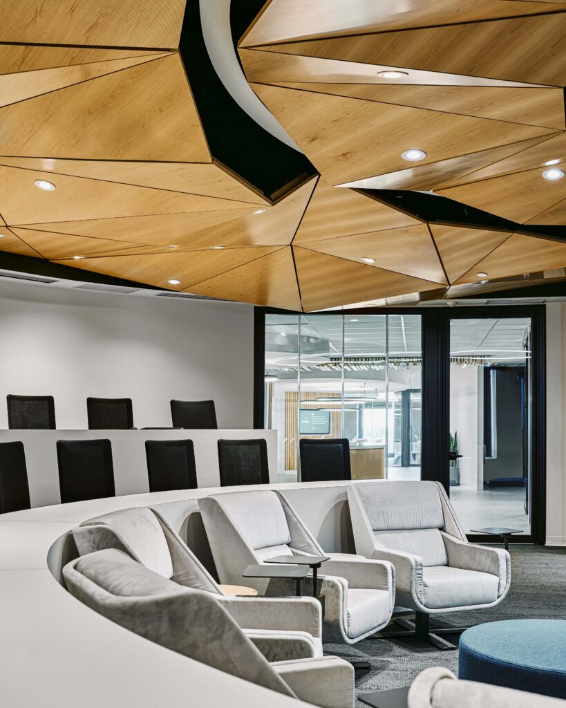 Town hall at Kinaxis headquarters — tiered seating beneath a faceted timber origami ceiling with 3G Lighting downlights set into the facets