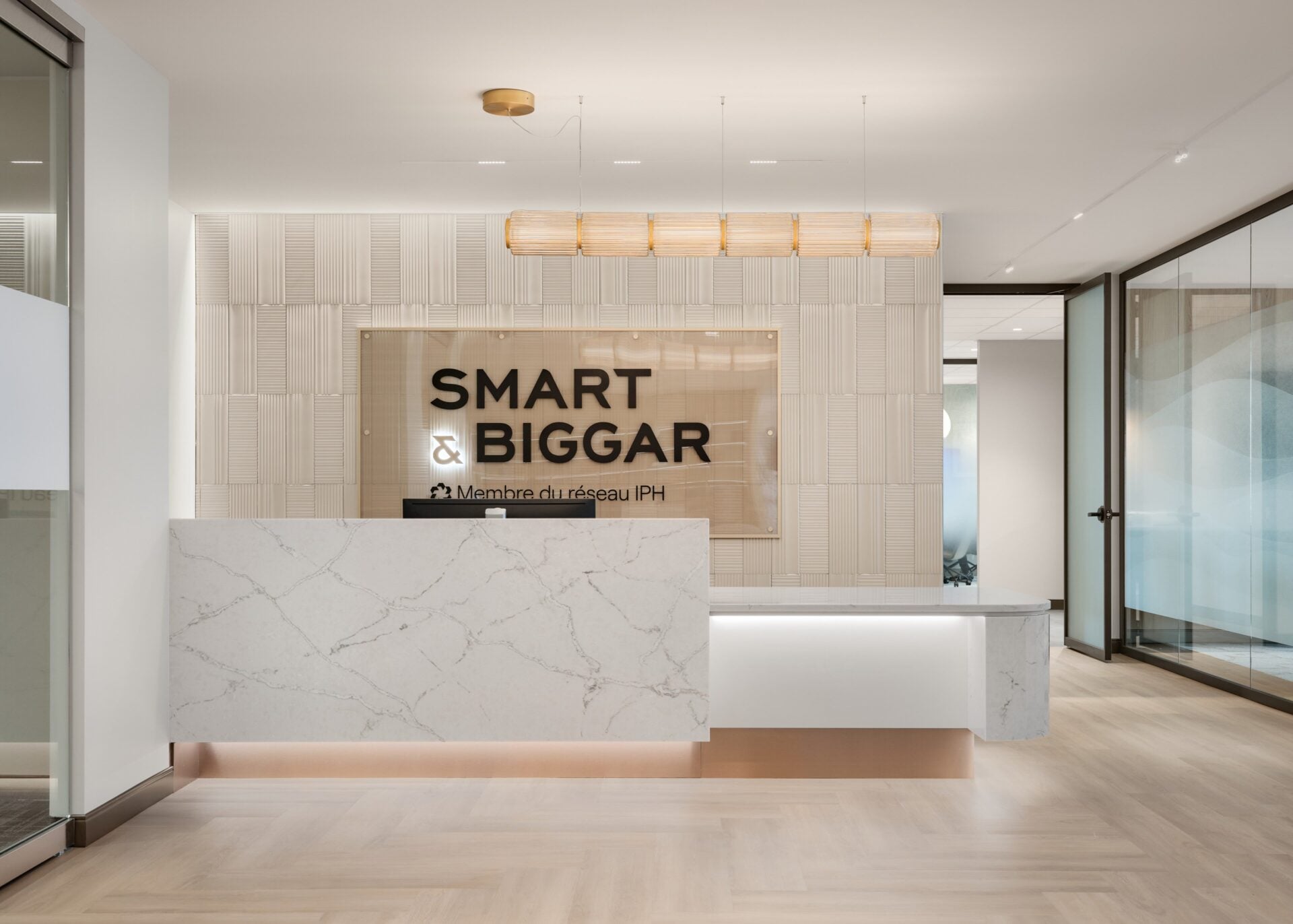 A-N-D Column pendant over the branded reception desk and felt acoustic wall at Smart & Biggar Montréal
