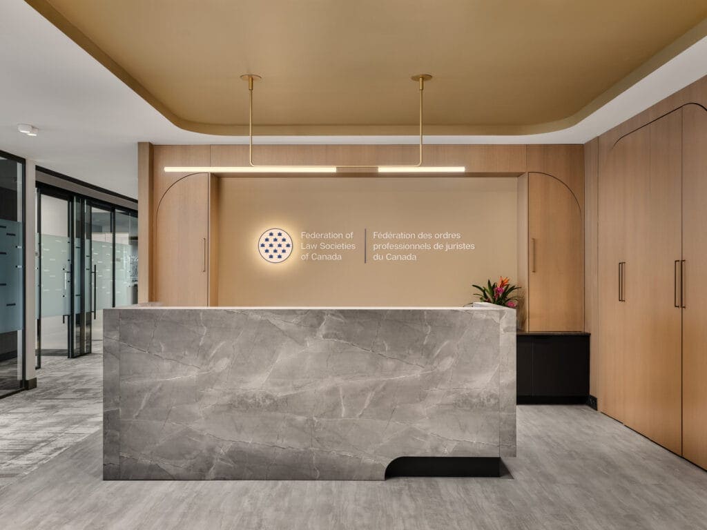 Backlit Federation of Law Societies crest and gold ceiling raft at the Ottawa reception desk