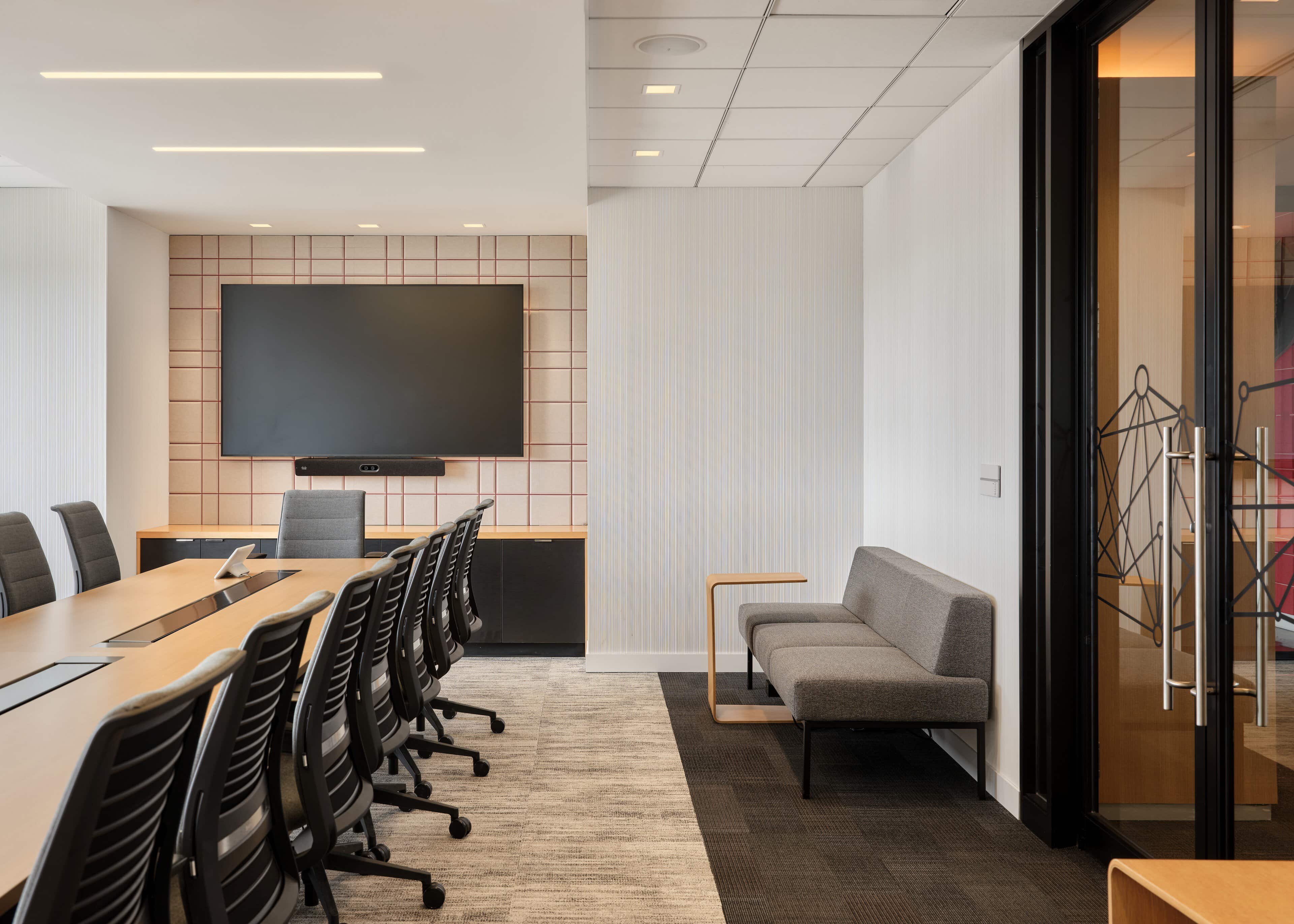 Boardroom with a blush grid acoustic panel behind the display at CIRA, Ottawa