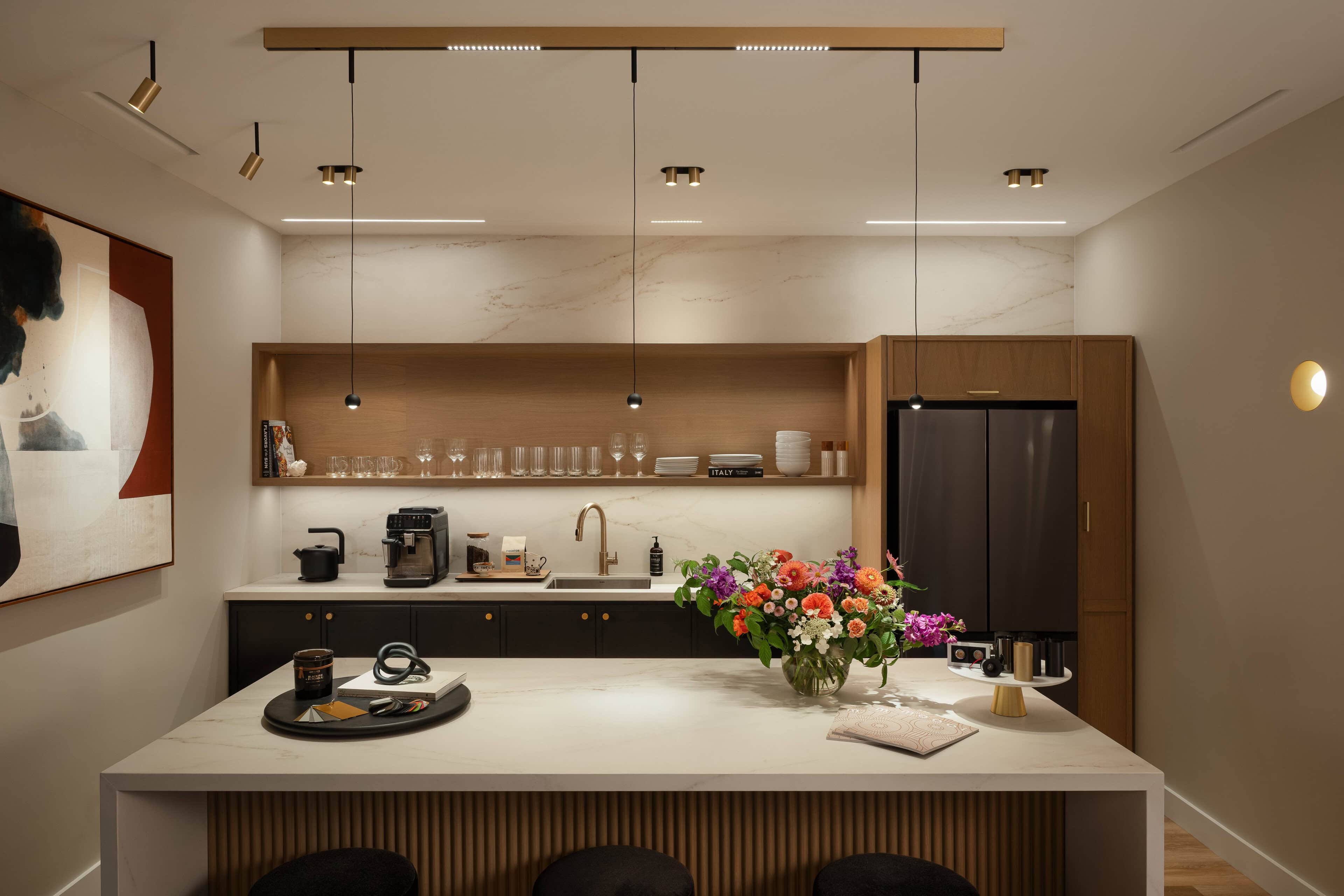 Flux Lighting showroom, Ottawa — a warm domestic kitchen with pendants over the island and lit open shelving.