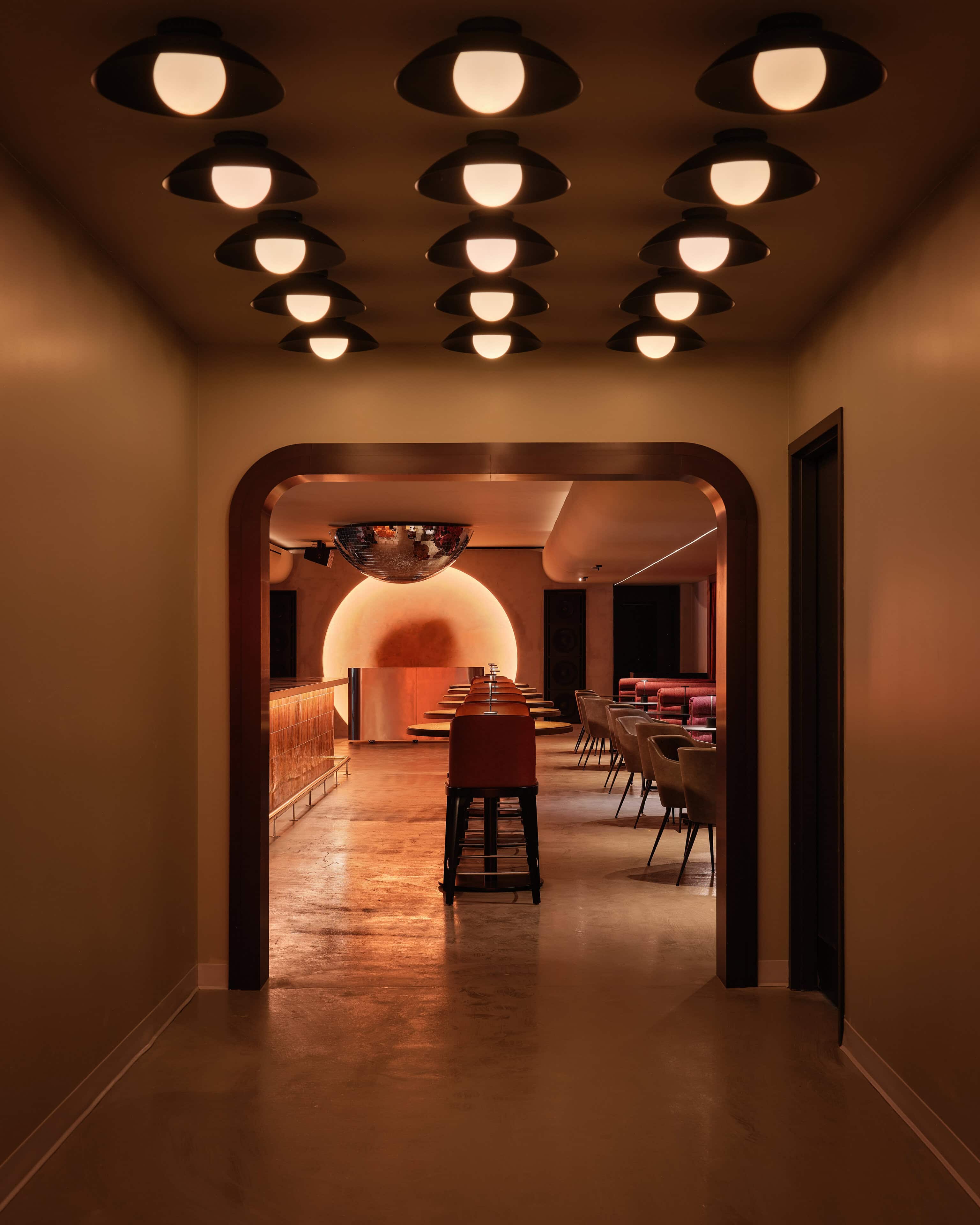 An arched opening at HISTORY Ottawa framing a view through to the illuminated disc beyond