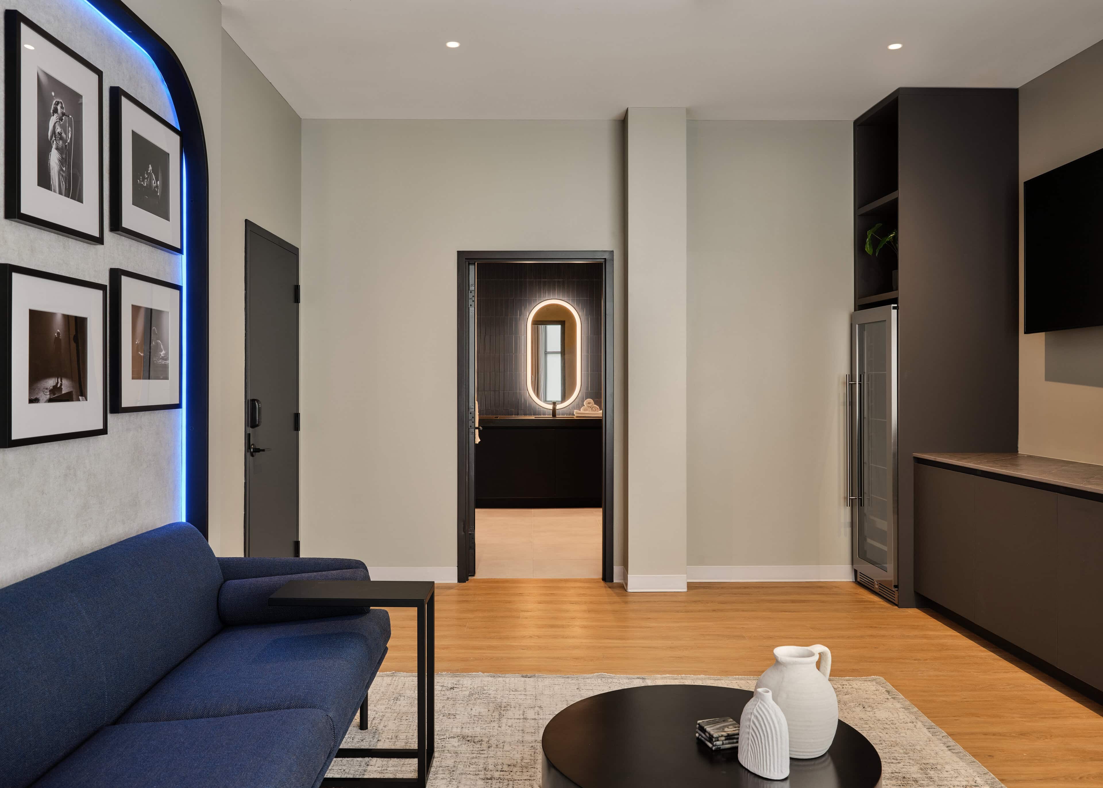 An artist lounge at HISTORY Ottawa with a gallery wall and a lit mirror in the room beyond