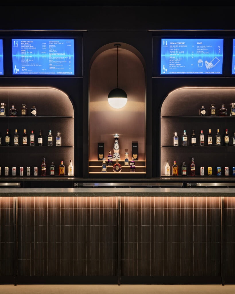 Close view of a Visual Comfort Akova globe pendant with a Ketra lamp above the backbar at HISTORY Ottawa