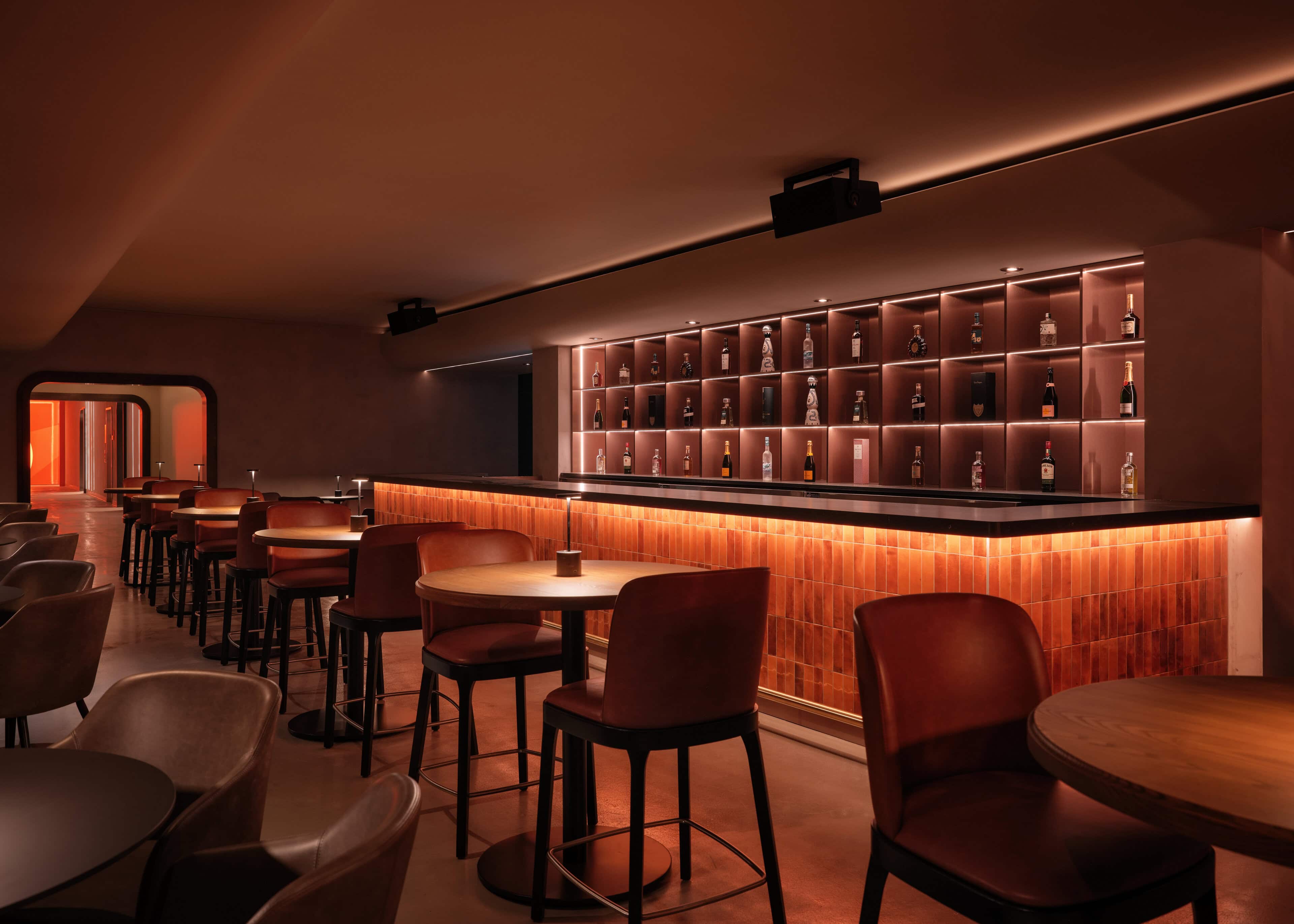 VIP bar at HISTORY Ottawa with illuminated bottle niches and a warm washed wall